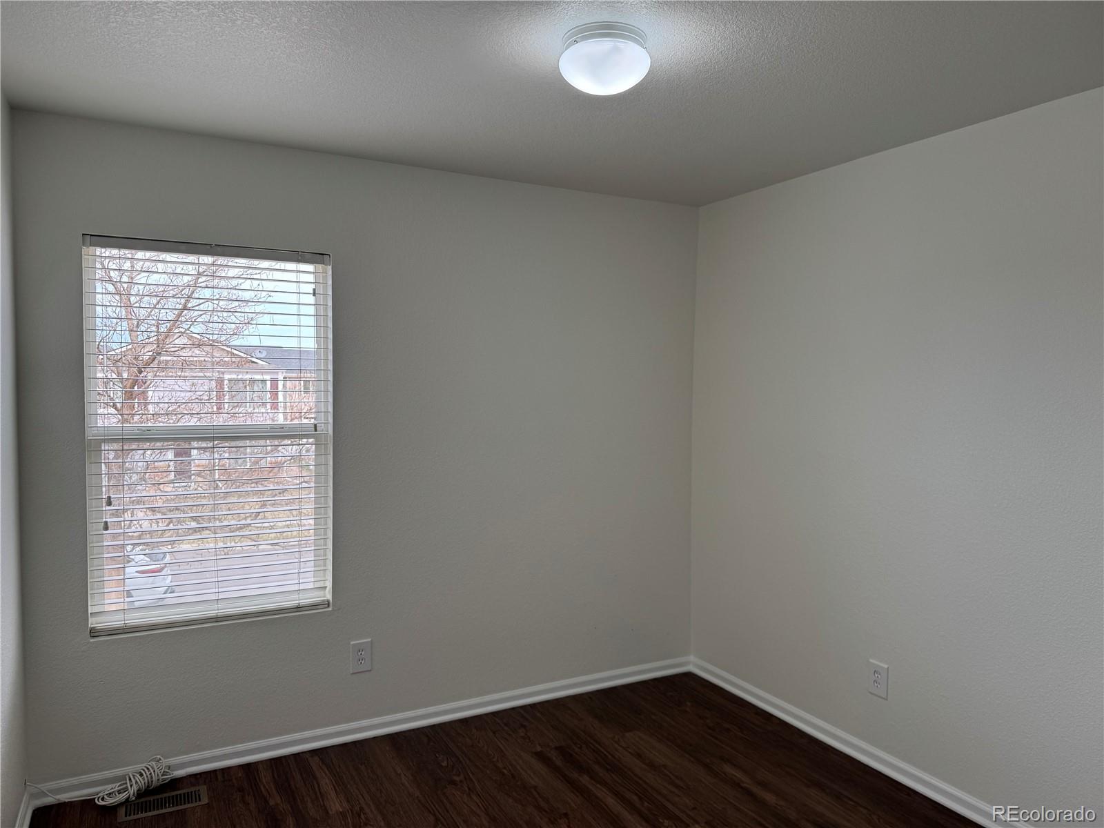 4726 Andes Street Denver, CO 80249 - Photo 12 of 17 an empty room with wooden floor and windows