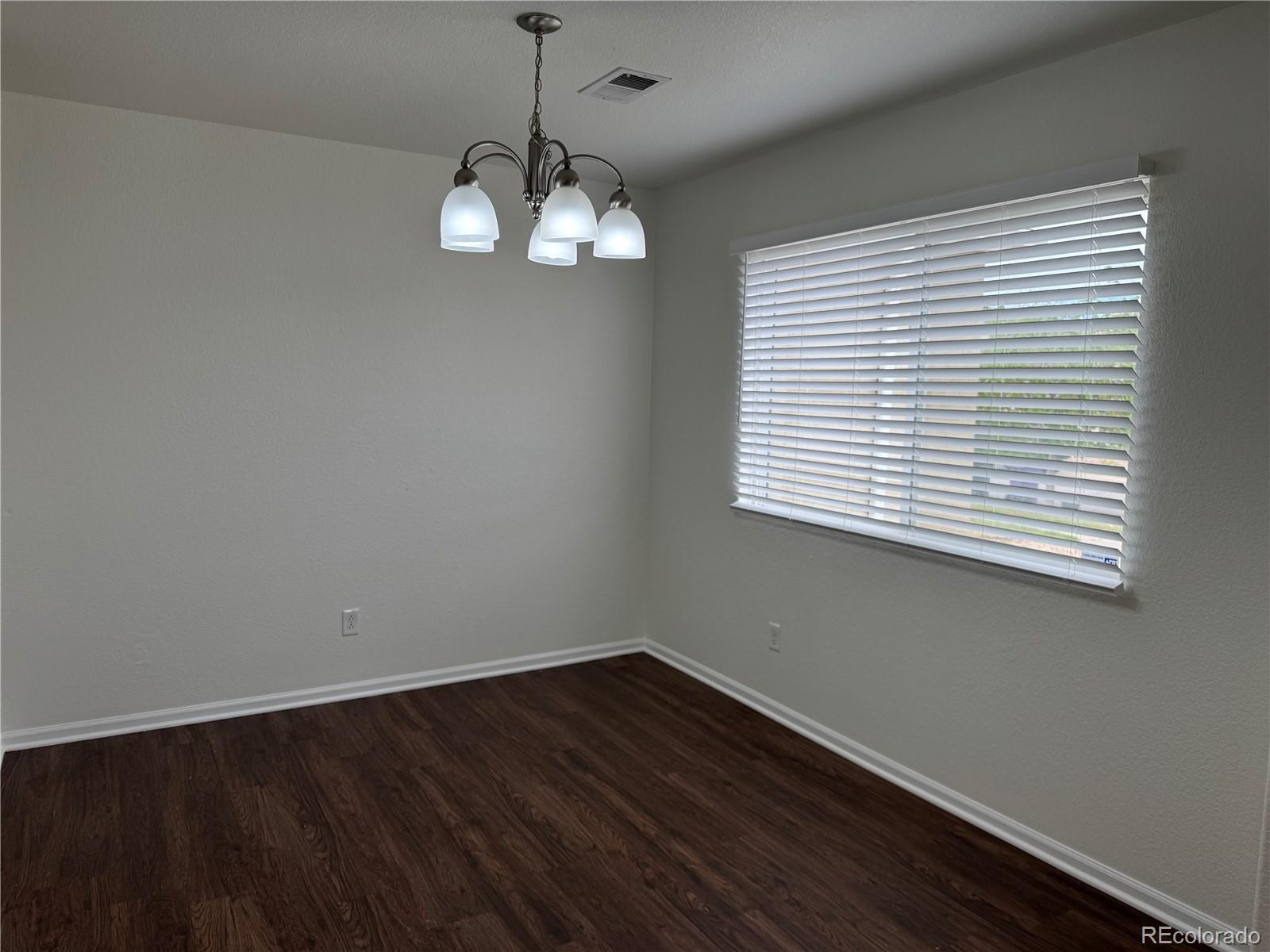 4726 Andes Street Denver, CO 80249 - Photo 2 of 17 an empty room with wooden floor and windows