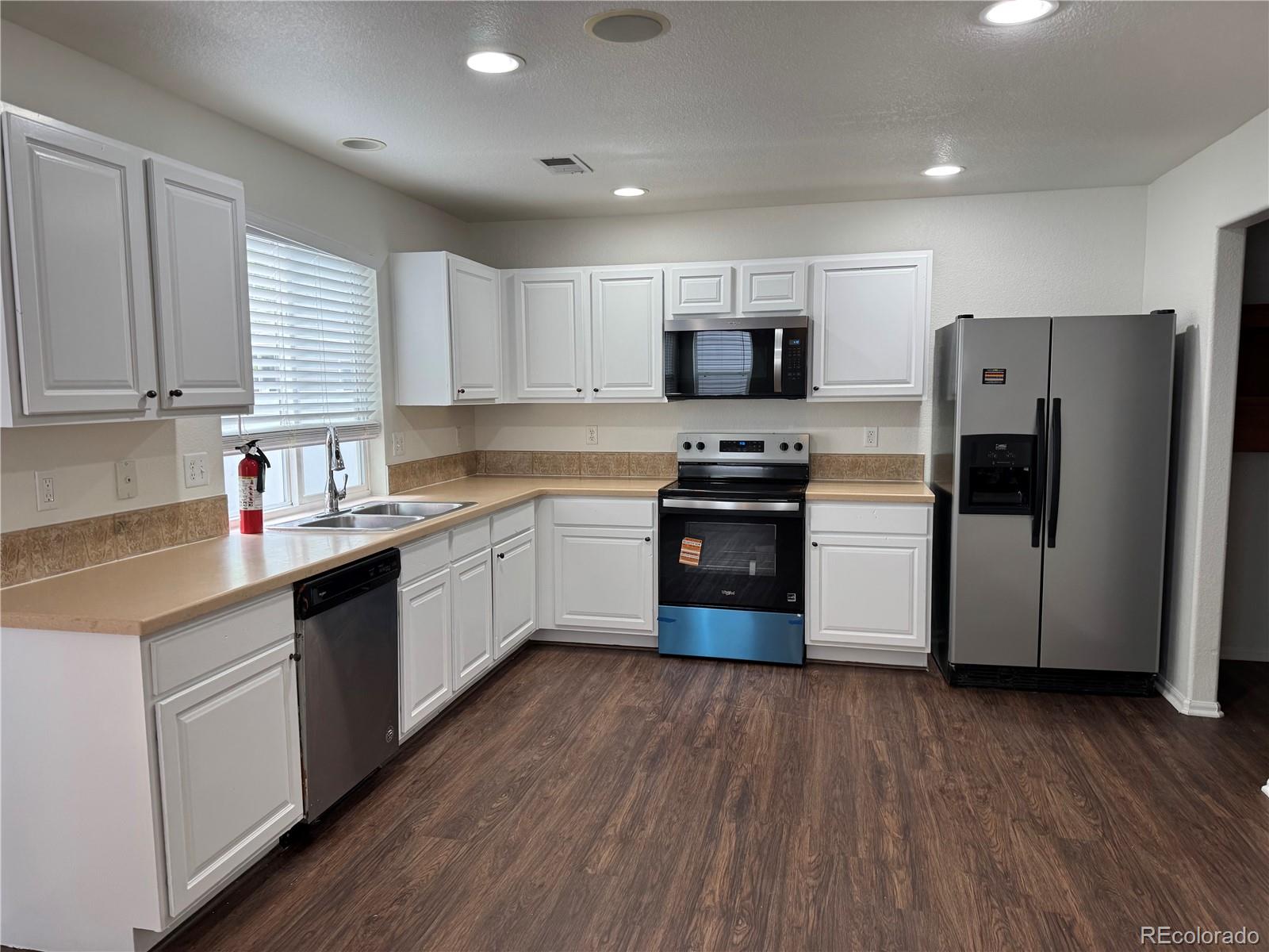 4726 Andes Street Denver, CO 80249 - Photo 6 of 17 a kitchen with stainless steel appliances a refrigerator sink and wooden cabinets
