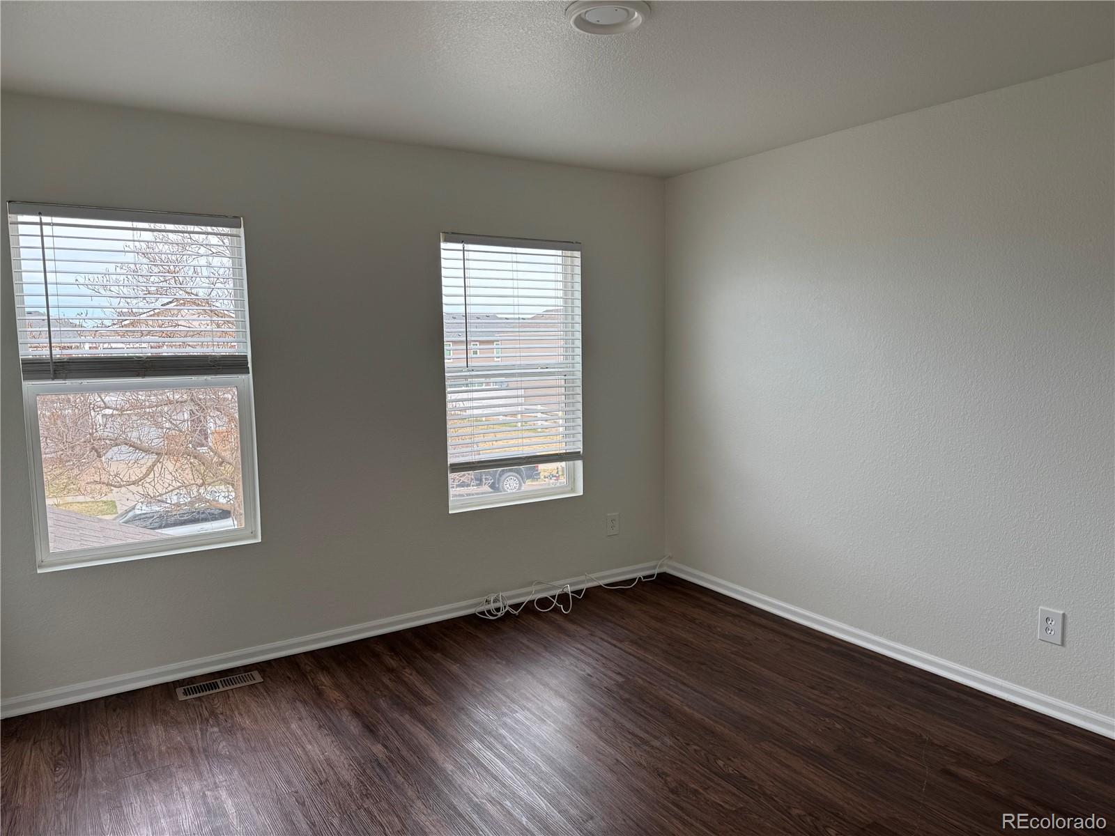4726 Andes Street Denver, CO 80249 - Photo 9 of 17 a view of an empty room with wooden floor and a window