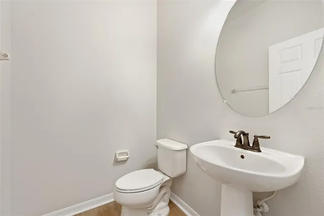 a bathroom with a sink a toilet and mirror