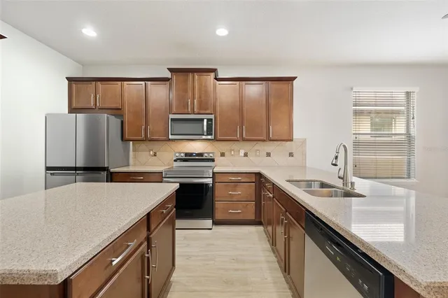 a kitchen with a refrigerator a sink and wooden cabinets