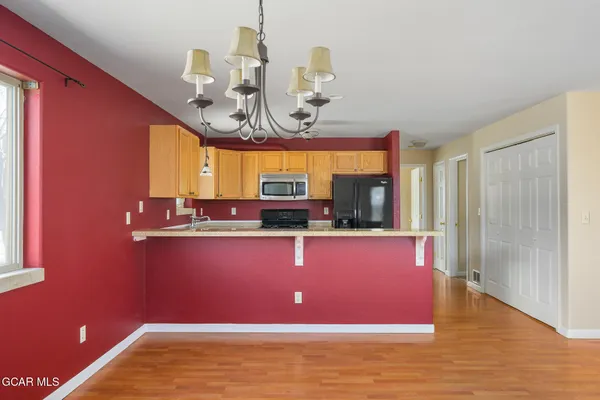 a view of a room with a chandelier windows and wooden floor