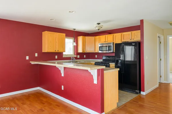 a kitchen with stainless steel appliances granite countertop a refrigerator a sink a stove top oven and a refrigerator