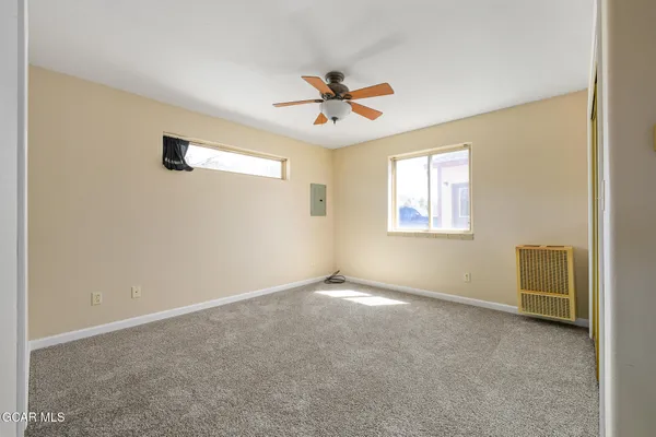 an empty room with closet and windows