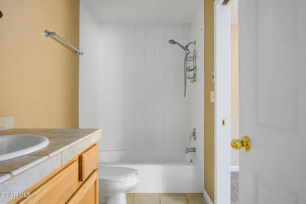 an empty room with windows and chandelier fan