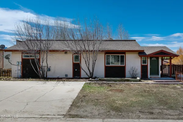 a view of a house with wooden deck front of house