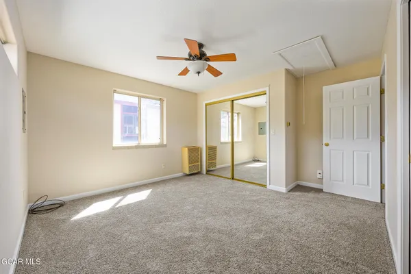 an empty room with windows and fan