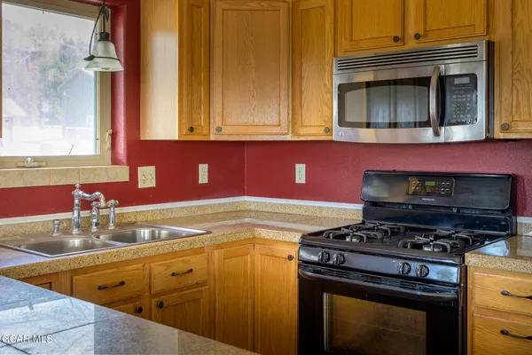 a kitchen with stainless steel appliances granite countertop a stove and a microwave