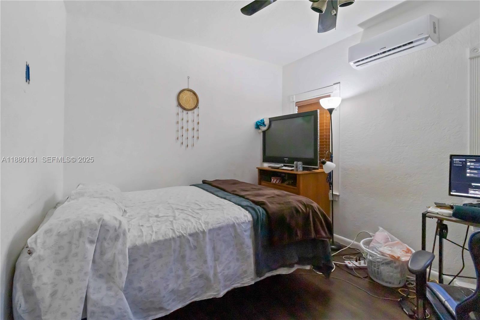 5740 Lincoln Street Hollywood, FL 33021 - Photo 21 of 28 a bedroom with a bed and a flat tv screen on a dresser