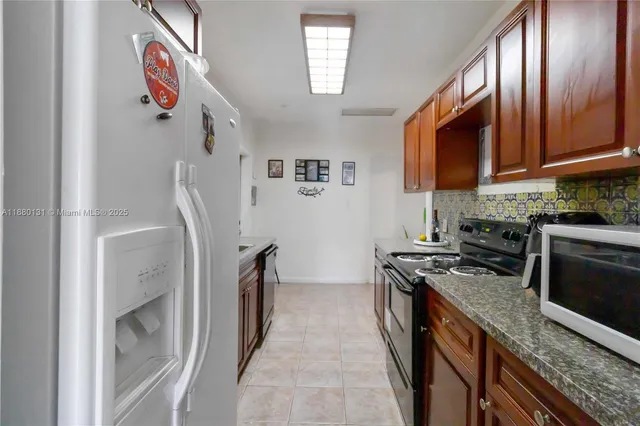 a kitchen with stainless steel appliances granite countertop a stove a refrigerator and a sink