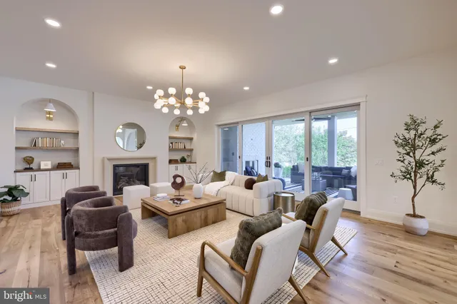a living room with furniture a chandelier a large window and a chandelier