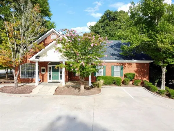 a front view of a house with a yard and potted plants