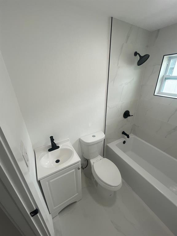 1457 West 31st Street, Unit 1 Riviera Beach, FL 33404 - Photo 13 of 16 a white toilet sitting next to a bath tub