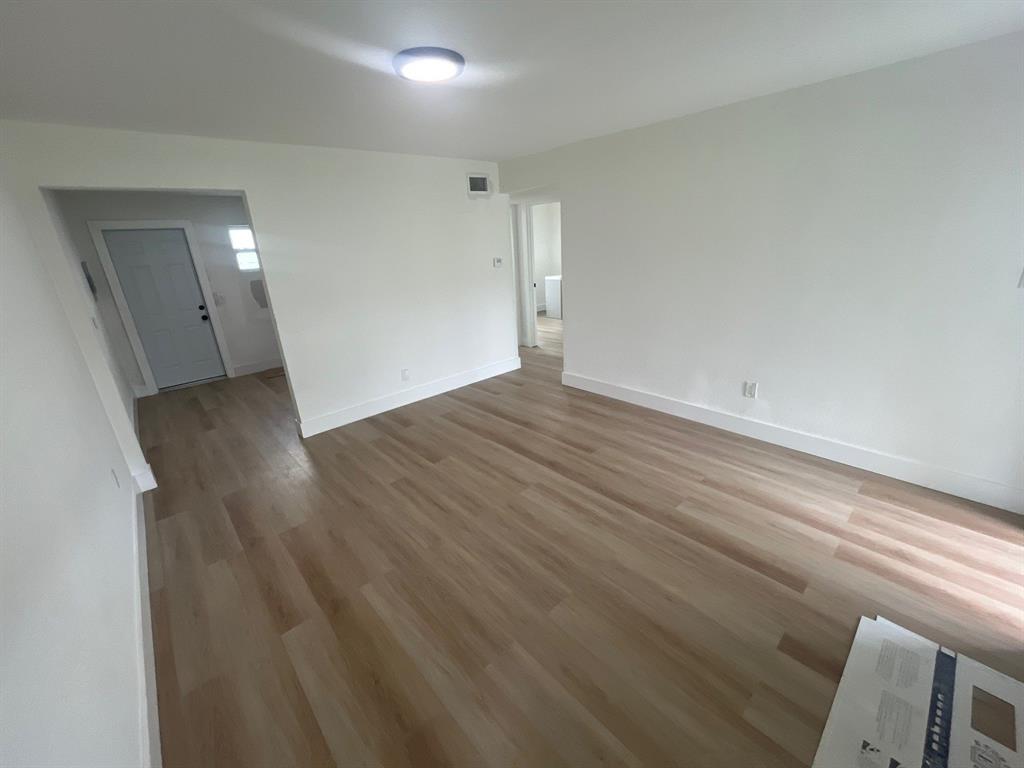 1457 West 31st Street, Unit 1 Riviera Beach, FL 33404 - Photo 4 of 16 an empty room with wooden floor and windows