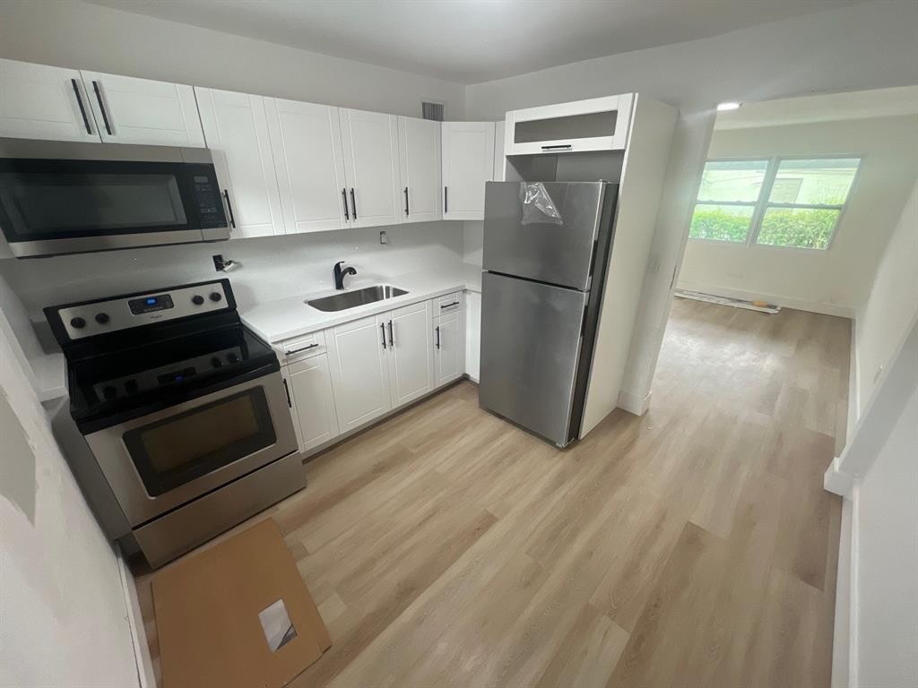 1457 West 31st Street, Unit 1 Riviera Beach, FL 33404 - Photo 5 of 16 a kitchen with a refrigerator stove and microwave