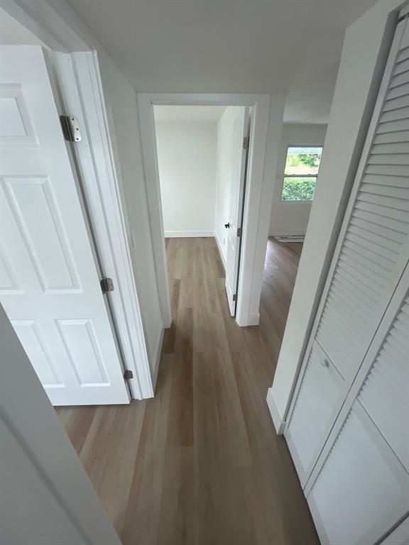 1457 West 31st Street, Unit 1 Riviera Beach, FL 33404 - Photo 10 of 16 a view of a hallway with wooden floor and staircase