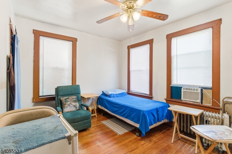 197 16th Avenue Paterson, NJ 07501 - Photo 14 of 23 a bedroom with a bed and a chandelier