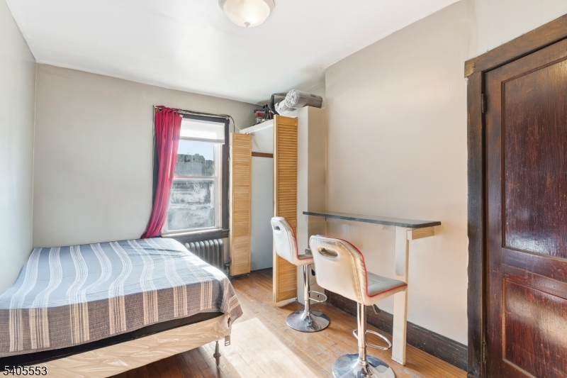 197 16th Avenue Paterson, NJ 07501 - Photo 15 of 23 a bedroom with a bed and a chandelier