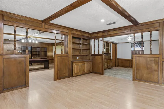 a large kitchen with stainless steel appliances kitchen island a large counter top and wooden floors