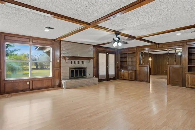 a view of an empty room with a fireplace and a window