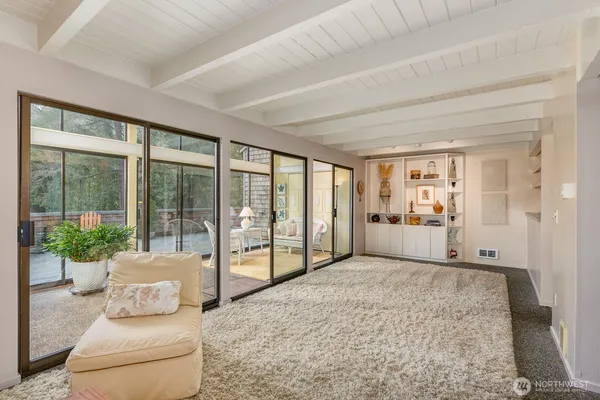 a bedroom with furniture and large windows with potted plants