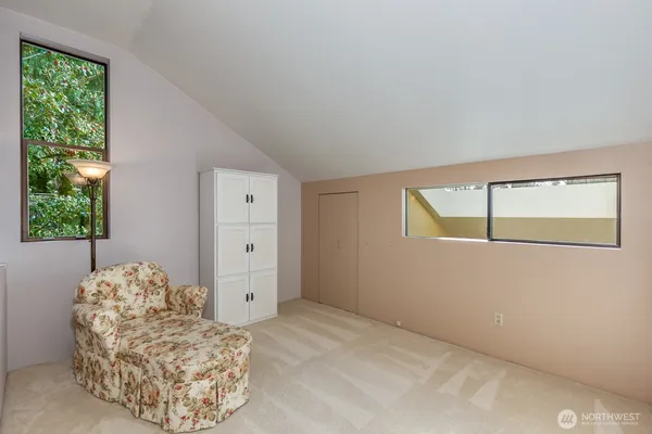 a bedroom with a large bed and a chandelier fan