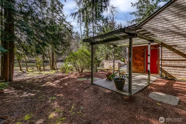 a view of a backyard with wooden fence and large trees