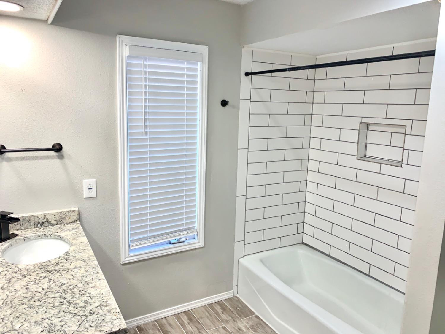 5708 91st Street Lubbock, TX 79424 - Photo 12 of 26 a bathroom with a bathtub and a shower