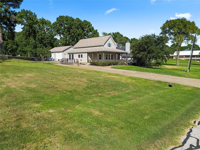 an aerial view of a house with a yard and lake view