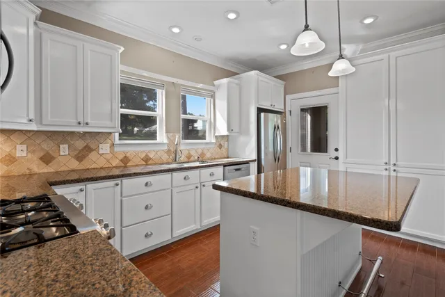 a kitchen with granite countertop a stove a sink and a granite counter top