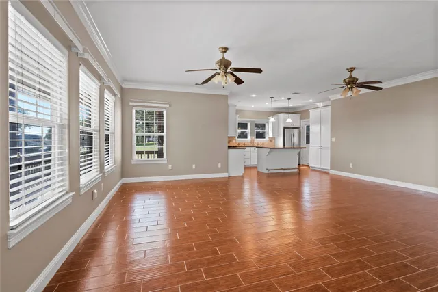 a view of an empty room with window and wooden floor