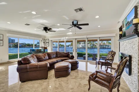 a living room with furniture ceiling fan and a floor to ceiling window