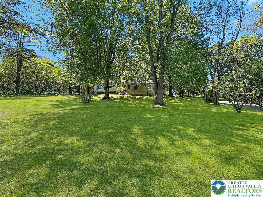 3406 Church Road Easton, PA 18045 - Photo 38 of 39 A verdant lawn gracefully slopes towards a charming residence nestled among mature trees.