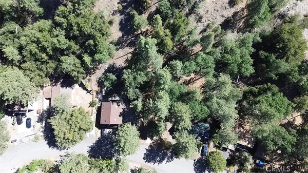 an aerial view of residential house with outdoor space and trees all around