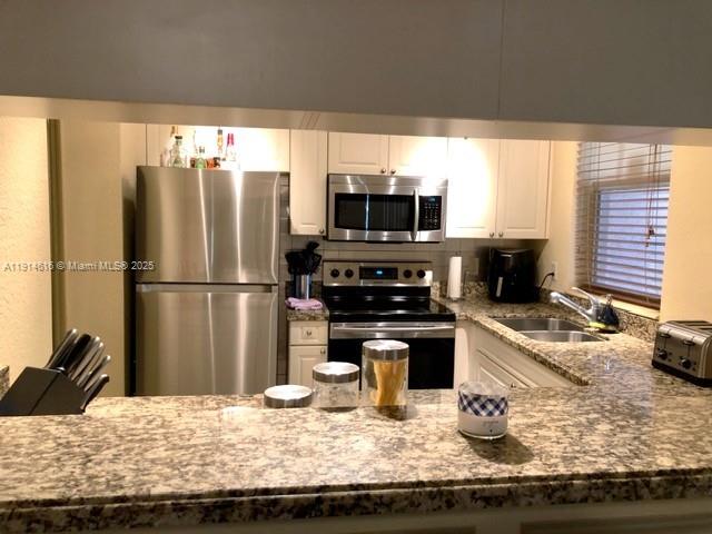 6584 West Sample Road, Unit 6584 Coral Springs, FL 33067 - Photo 3 of 13 a kitchen with granite countertop a refrigerator and a stove top oven