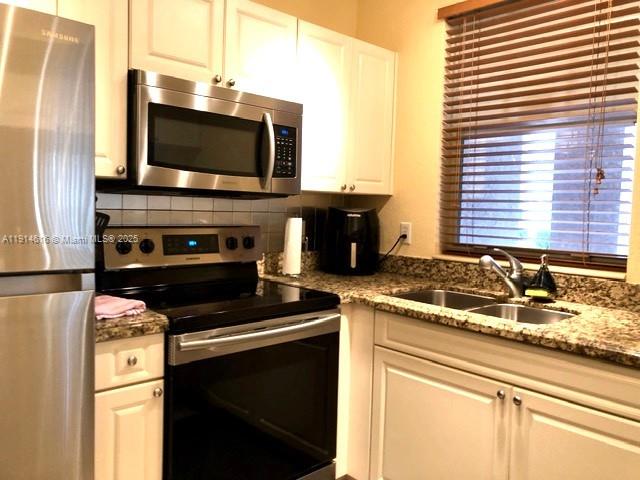 6584 West Sample Road, Unit 6584 Coral Springs, FL 33067 - Photo 4 of 13 a kitchen with a stove and a microwave