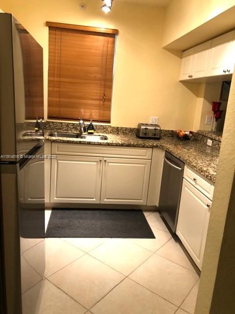 6584 West Sample Road, Unit 6584 Coral Springs, FL 33067 - Photo 6 of 13 a kitchen with a sink a stove and white cabinets