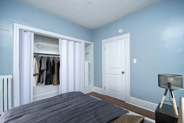 a view of a hallway with wooden floor and closet