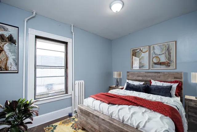 a bedroom with a bed and a painting on the wall