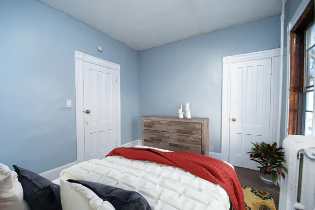 a bedroom with a bed and a potted plant