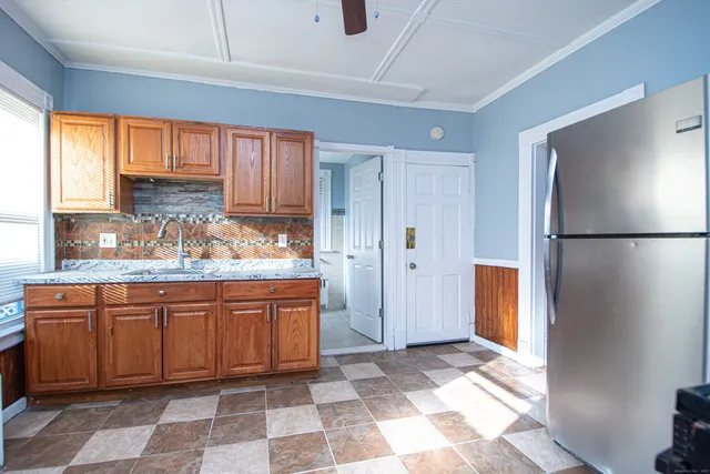 a kitchen with stainless steel appliances granite countertop a refrigerator and a sink