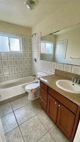a bathroom with a granite countertop sink a toilet a mirror and shower