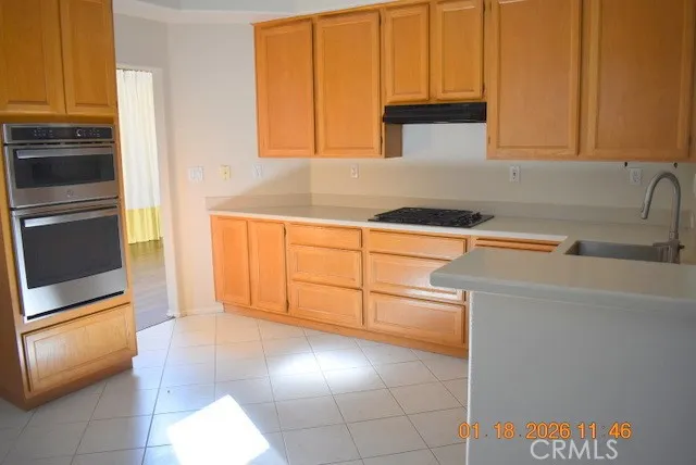 a kitchen with granite countertop a stove a sink and a microwave