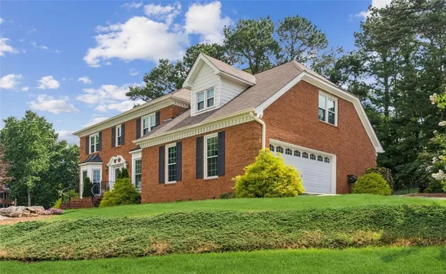 a view of a brick house with a yard
