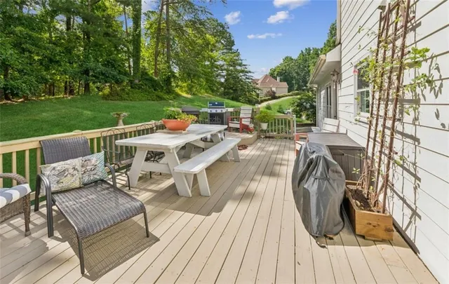 a view of a patio with table and chairs with wooden floor and fence