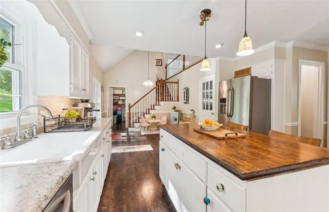 a kitchen with stainless steel appliances granite countertop a sink stove and refrigerator