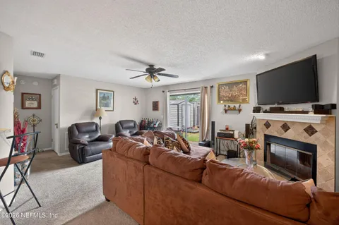 a living room with furniture a flat screen tv and a window