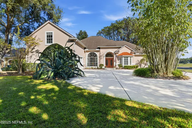 a view of a yard in front of a house with a large tree