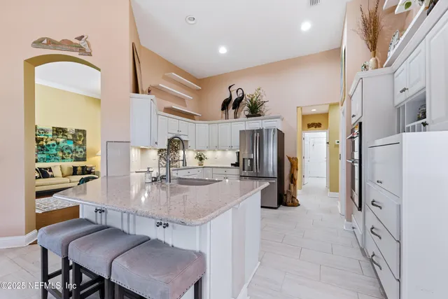 a kitchen with white cabinets and sink